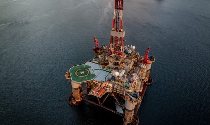Oil rig in the sea with a helicopter landing pad from an aerial perspective
