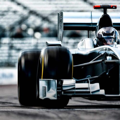 Motorsport vehicle on track with a clear view of the driver